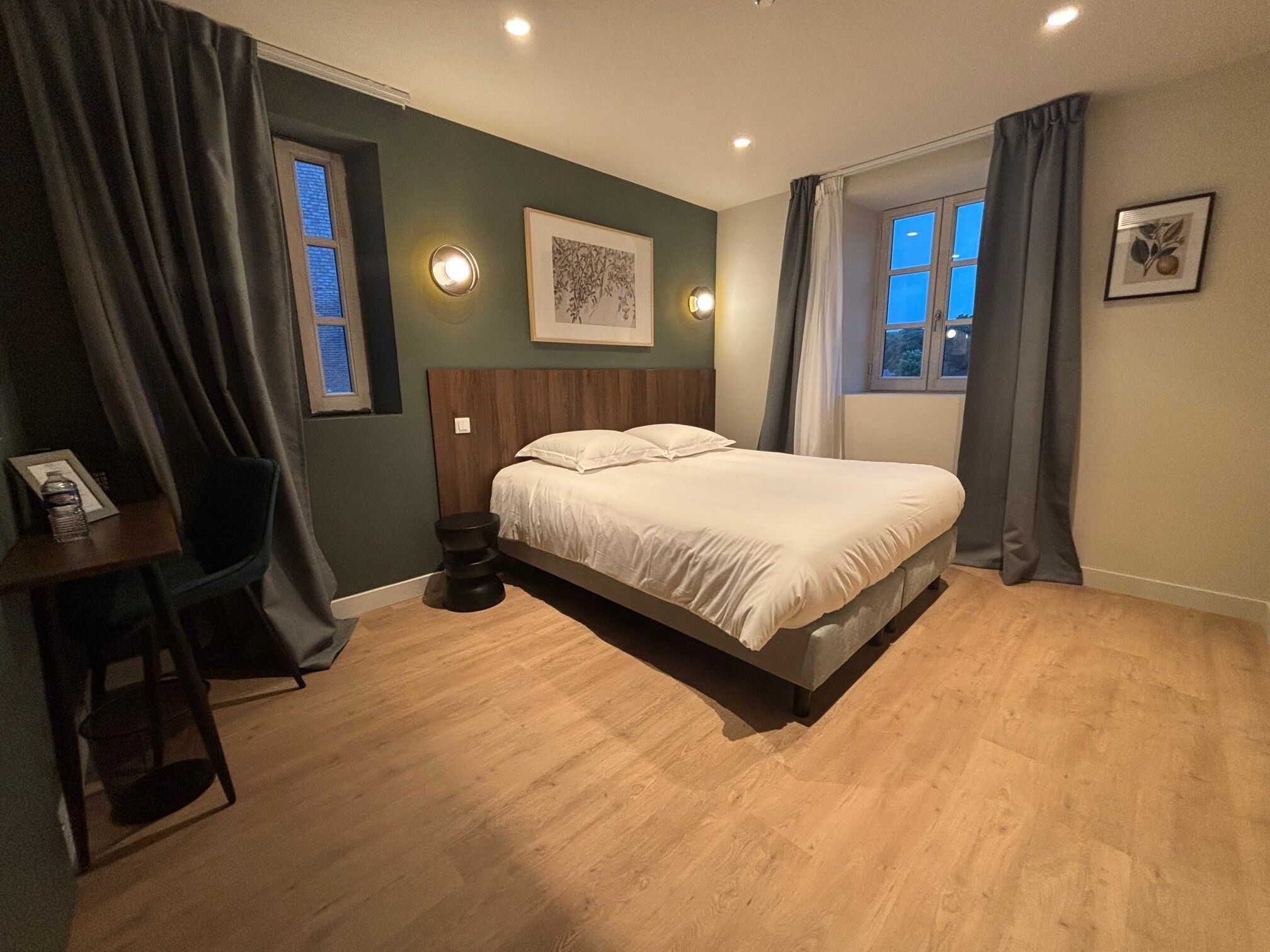A bedroom with a bed, a desk, and a chair.