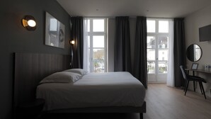 Une chambre moderne avec un grand lit, un bureau et une chaise.