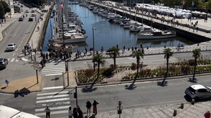 Un port de plaisance avec des bateaux amarrés, une promenade piétonne et des espaces de détente en plein air.