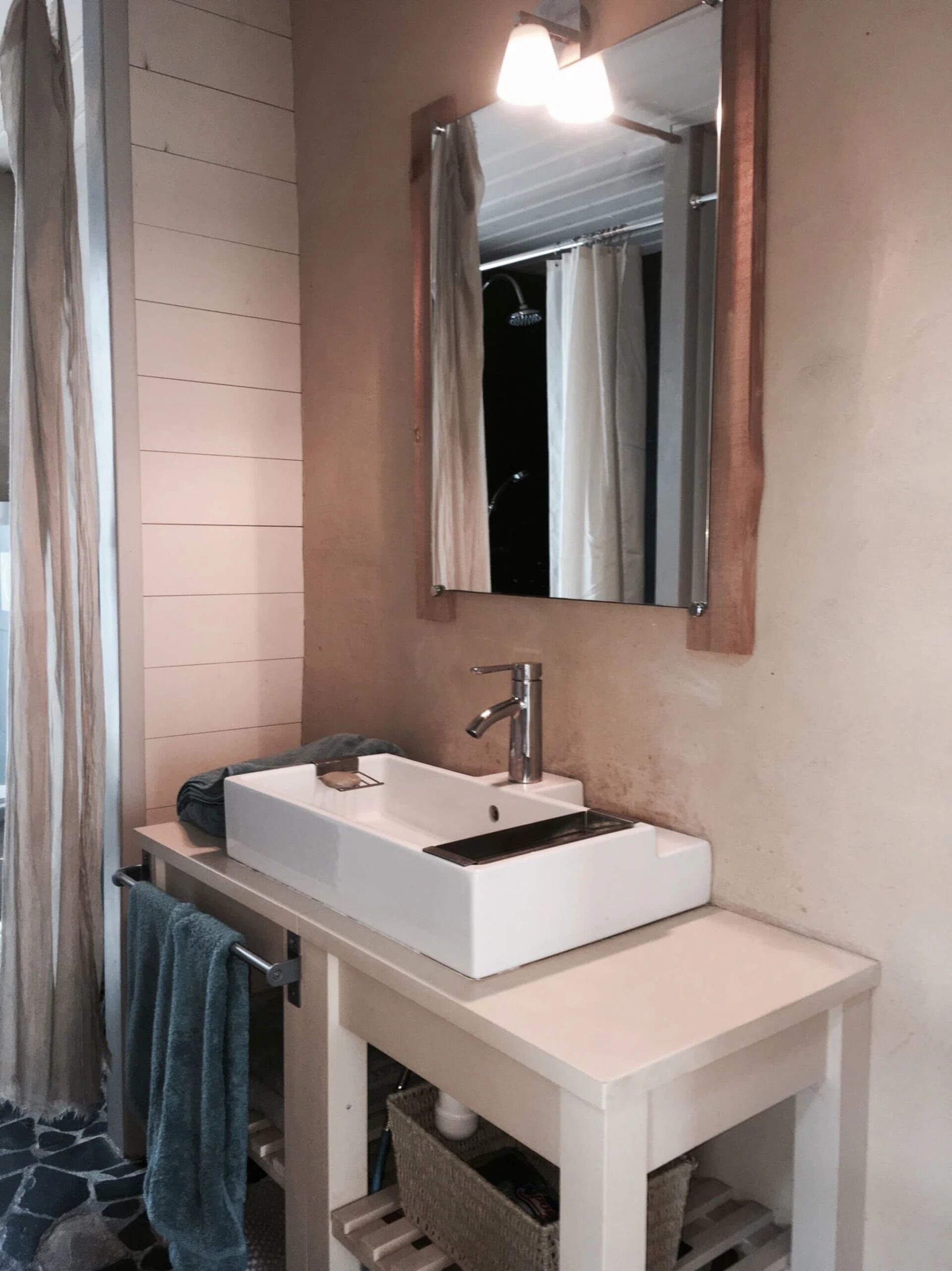 Une salle de bain avec un lavabo blanc, un miroir et un porte-serviettes.