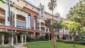 Un hôtel doté d’une cour intérieure, de nombreux balcons et présentant un mélange de styles architecturaux, notamment des arches et des éléments modernes.