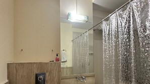 A bathroom with a toilet, sink, and shower curtain. - VR RESIDENCY (Gurugram)