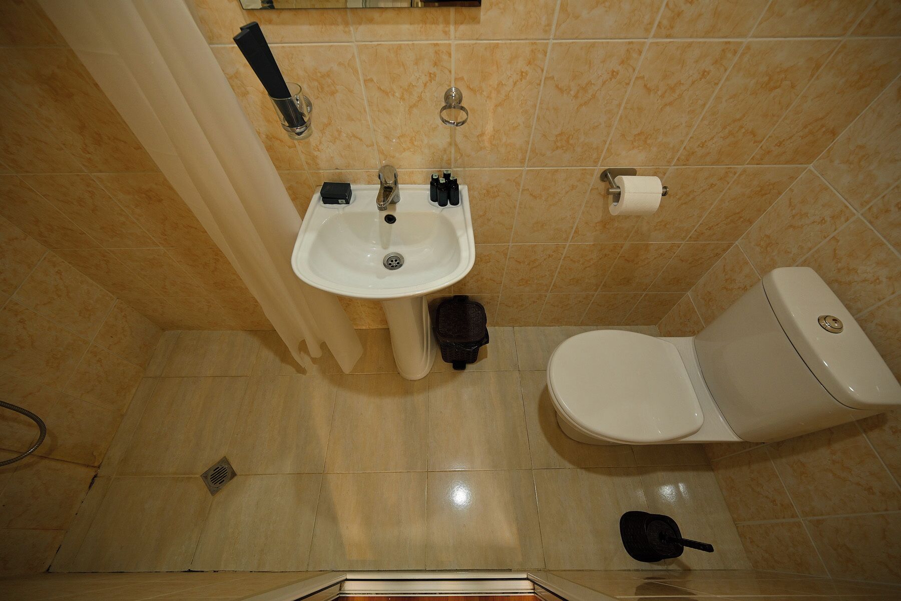 Un baño con lavamanos, inodoro y cortina de ducha.
