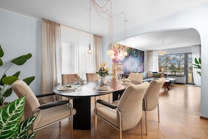A modern dining room with a round table set for six, surrounded by six chairs.