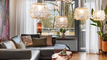 Ein modernes Wohnzimmer mit einer Couch, einem Couchtisch und dekorativer Beleuchtung.