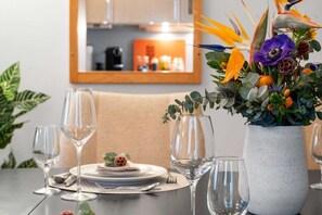 A dining table set for four with wine glasses and a centerpiece of flowers.