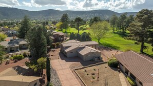 Zona residencial con casas, un campo de golf y montañas al fondo.