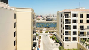 A multi-story building with balconies, a central courtyard, and a view of the sea. - HiGuests - La Rive Classy 2BR & Balcony (Dubai)