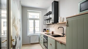 Una cocina moderna con ventana, horno empotrado y encimera de madera.