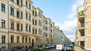A row of multi-story buildings with a uniform architectural style, featuring balconies and large windows.