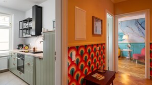 A kitchen with a built-in oven, a black range hood, and a countertop with a sink.