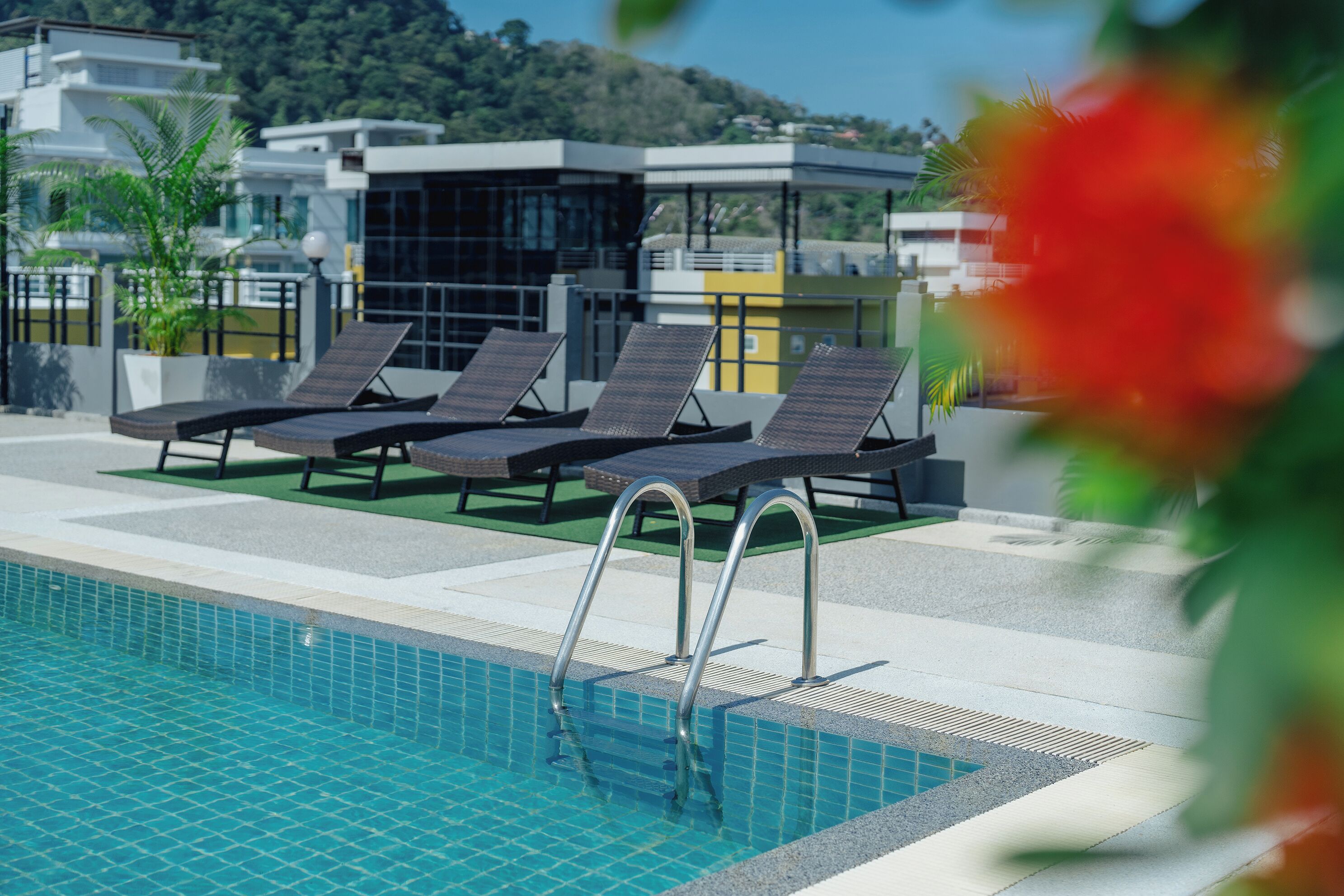 Une piscine avec des chaises longues et une vue sur des bâtiments modernes.