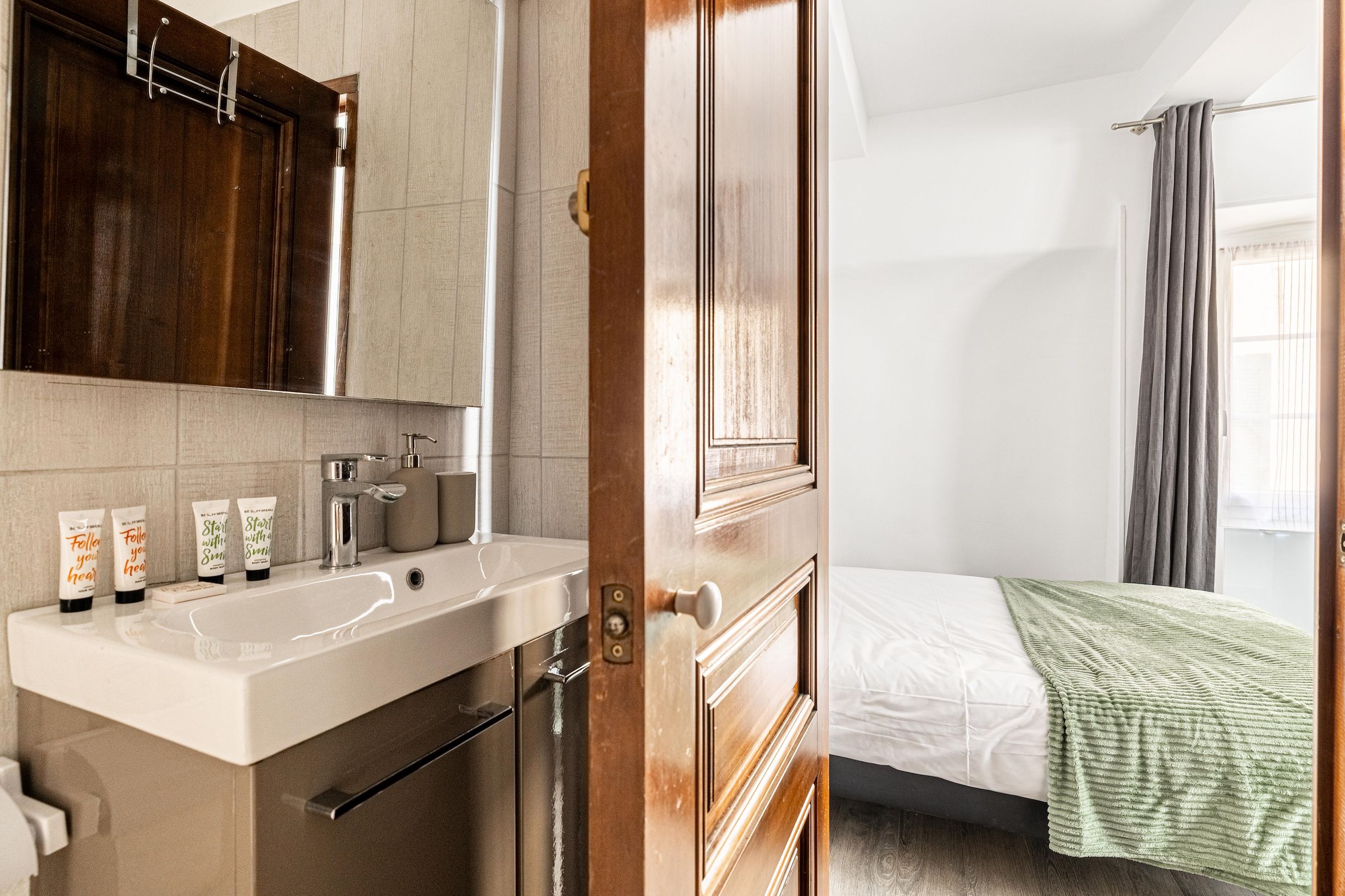 Une salle de bain équipée d’un lavabo, d’un miroir et d’articles de toilette.