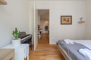 Um quarto com uma cama, um piano e um vaso de planta.