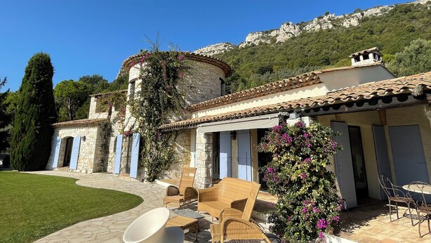 A stone building with a tiled roof, outdoor seating, and a garden. - Villa Bougainvilliers (Vence)