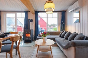 A cozy living room with a sofa, a round wooden table, and a fireplace.