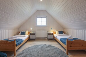 A cozy attic bedroom with two wooden beds, a window, and a radiator. - House - fireplace, sauna - 6 people (Wandlitz)