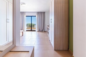 Un corridoio con vista su un balcone, un armadio in legno e una panca.