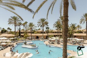 Una piscina al aire libre, sombrillas, sillones reclinables de piscina