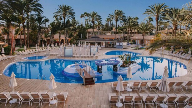 A large outdoor swimming pool surrounded by palm trees and lounge chairs. - Hotiday Gran Canaria Maspalomas (San Bartolome de Tirajana)