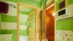 A bathroom with green and white tiles, a wooden door, a shower, and a sauna control panel. - Beautiful private villa with WIFI, private pool, TV, terrace, pets allowed and panoramic view (Semily)