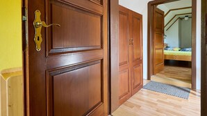 A wooden door with a brass handle, leading to a room with a bed and a small window. - Beautiful private villa with WIFI, private pool, TV, terrace, pets allowed and panoramic view (Semily)