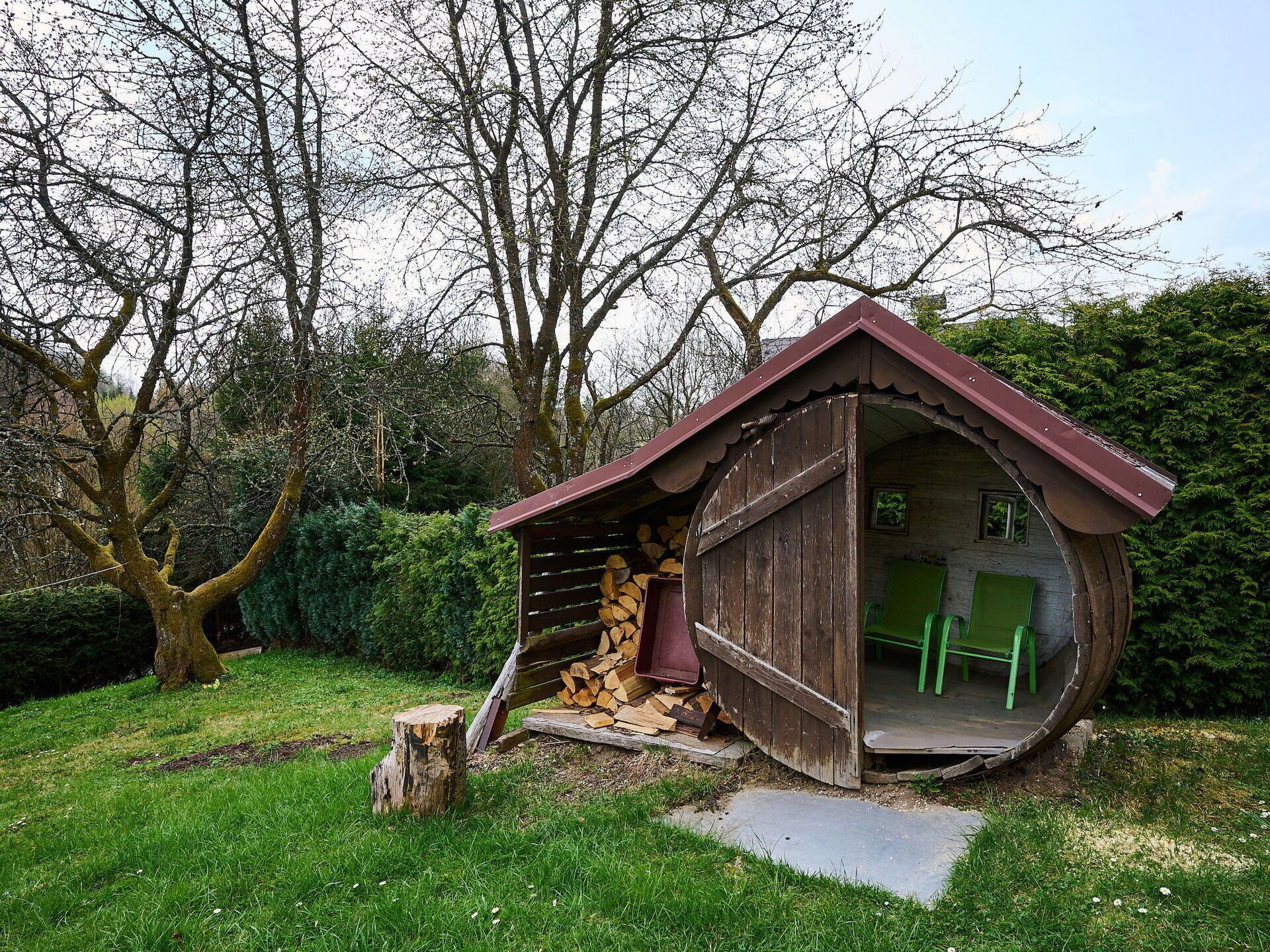 A rustic wooden structure with a sloped roof, a door, and a small window.