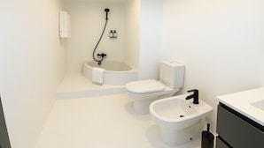 Une salle de bain moderne avec une baignoire, des toilettes et un lavabo.
