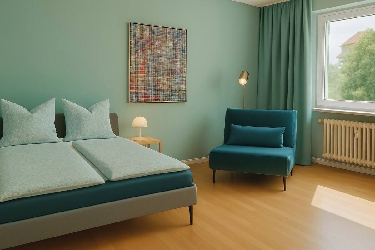 Een moderne slaapkamer met een bed, een stoel, een lamp en een raam met gordijnen.