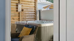 A wooden spa area with a hot tub, wicker chairs, and a wooden wall with labels. - Bombastic Bungalow Beach Home, just a 9 minute walk from the beach! (Panama City Beach)