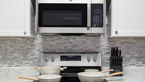 A kitchen with a microwave, oven, and stovetop.