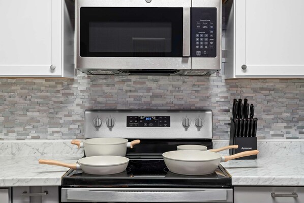 Una cocina equipada con microondas, horno y estufa.