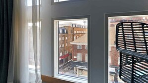 Vistall des de la finestra que mostra un carrer, un Starbucks i una cadira negra.