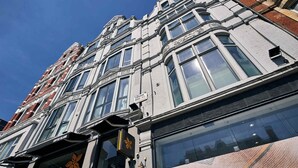 Un edifici de diversos pisos amb grans finestres i un estil arquitectònic clàssic.