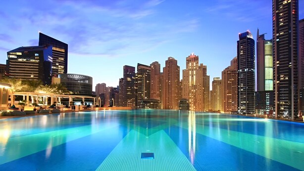 A swimming pool with a cityscape in the background.
