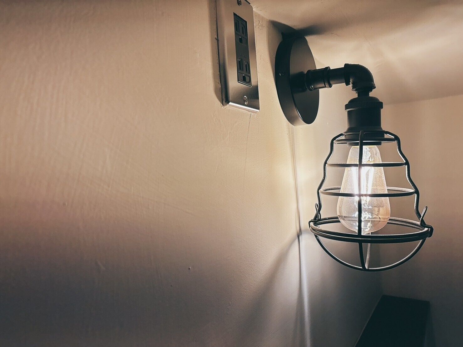 Eine Wandleuchte mit einer Glühbirne aus Klarglas.