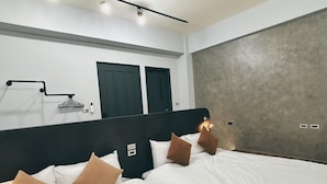 Una camera da letto moderna con un letto grande, una testiera nera e una parete grigia con texture.