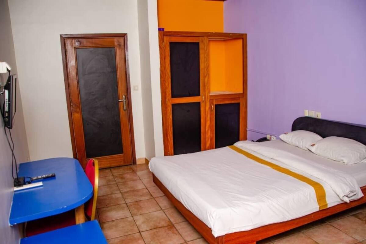 A room with a bed, a desk, and a wardrobe.