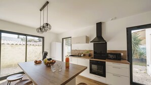 Una cucina moderna con isola in legno, mobili bianchi e cappa aspirante nera.