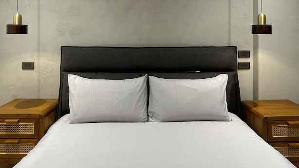 A modern hotel room with a large bed, two bedside tables, and pendant lights. - Wu Sheng Stay (Tainan)