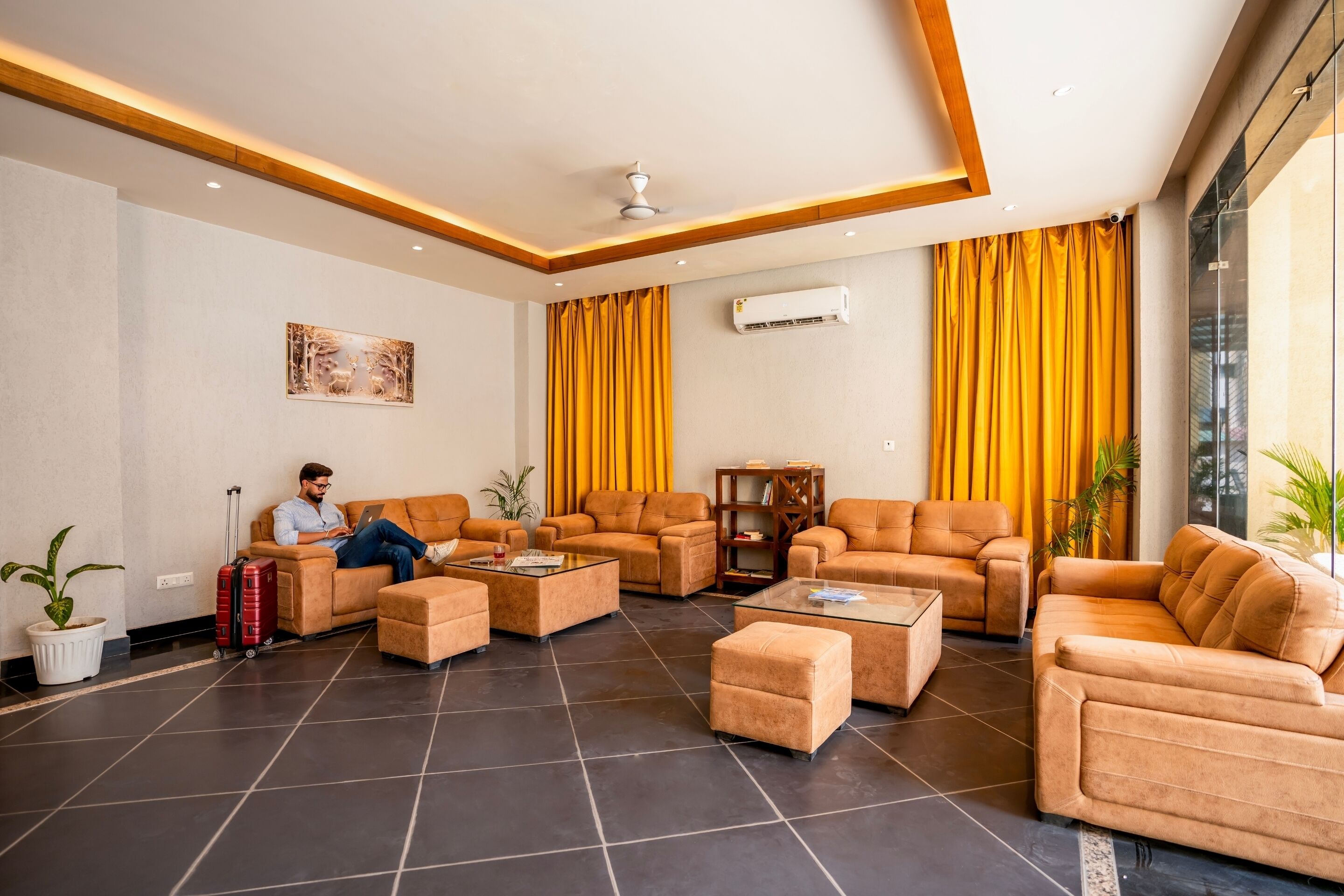 A spacious lobby with leather sofas, a coffee table, and a potted plant.