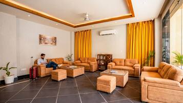 A spacious lobby with leather sofas, a coffee table, and a potted plant.