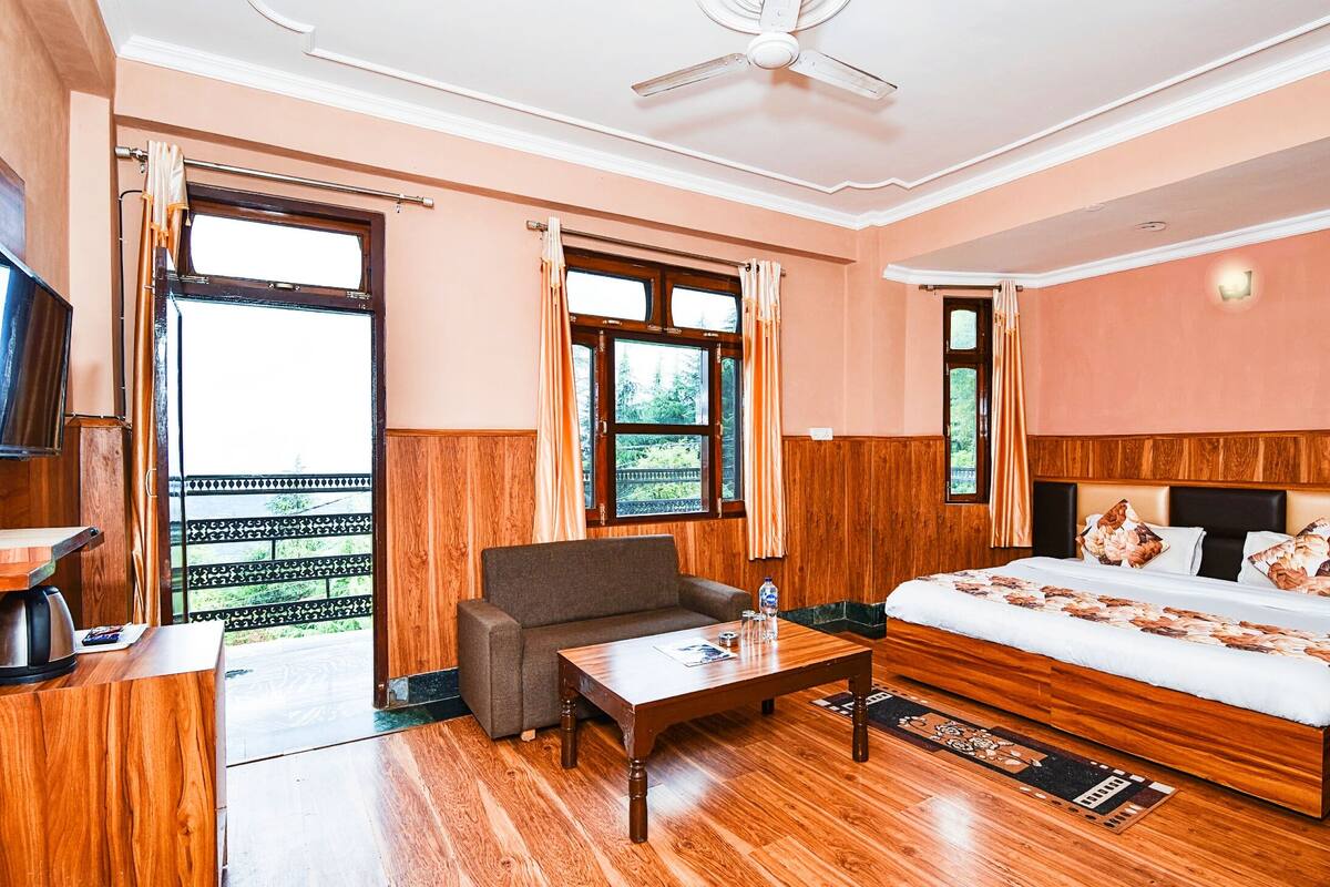 Une chambre d’hôtel avec un lit, un canapé, une table basse et un téléviseur.