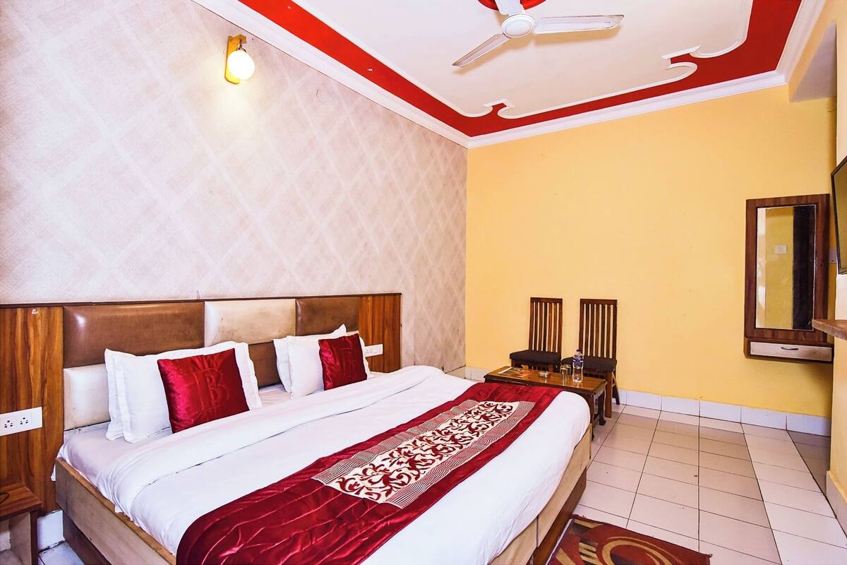 Une chambre d’hôtel avec un grand lit, un ventilateur de plafond, une télévision et une table de chevet.