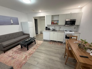 A modern apartment with a living room, kitchenette, and a dining area.
