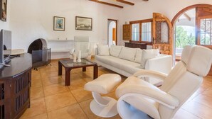 A living room with a sofa, armchairs, a coffee table, and a fireplace. - Villa Yuca in La Mandarina (Javea)