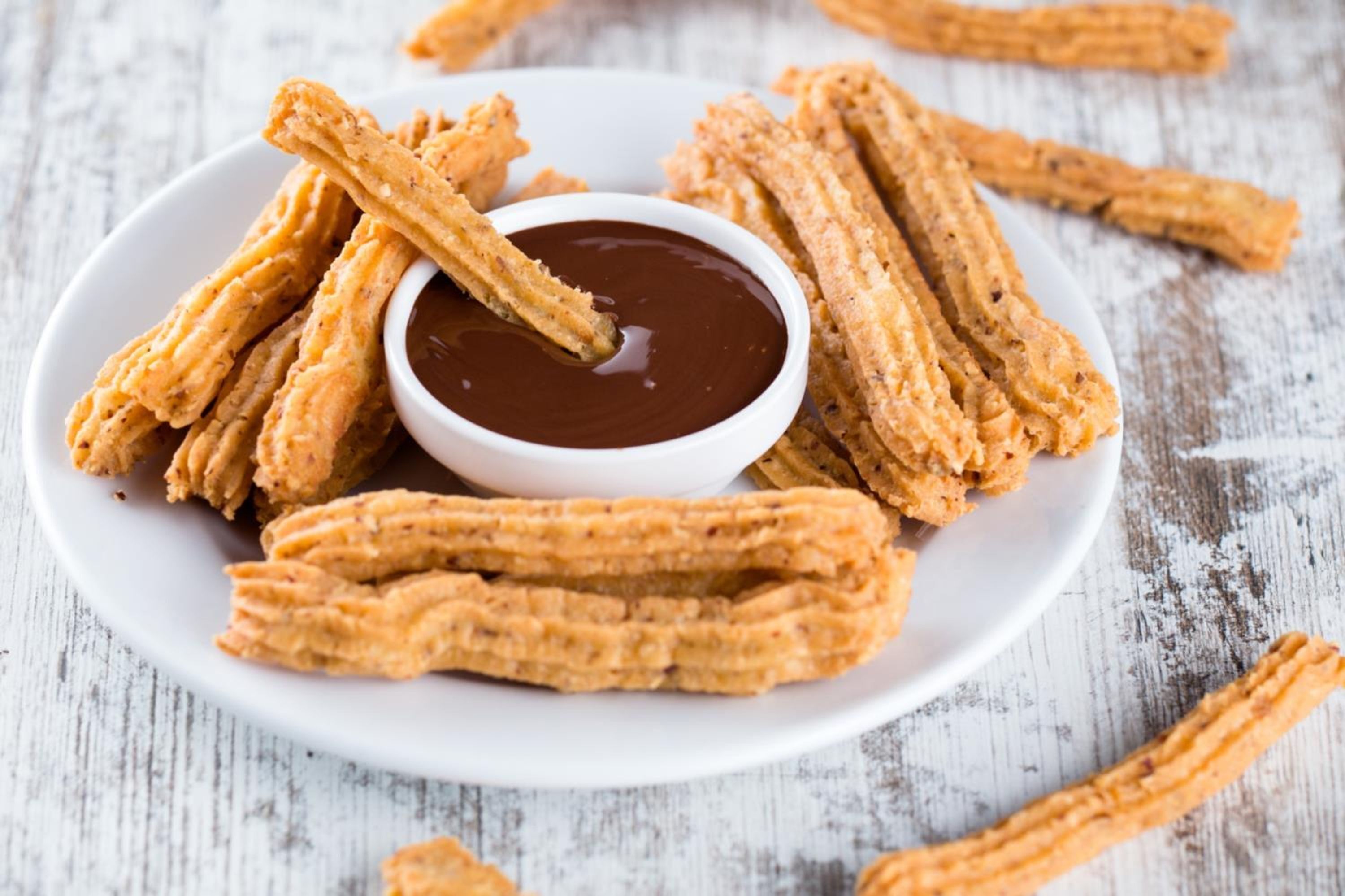 Un plato de churros con salsa para mojar.
