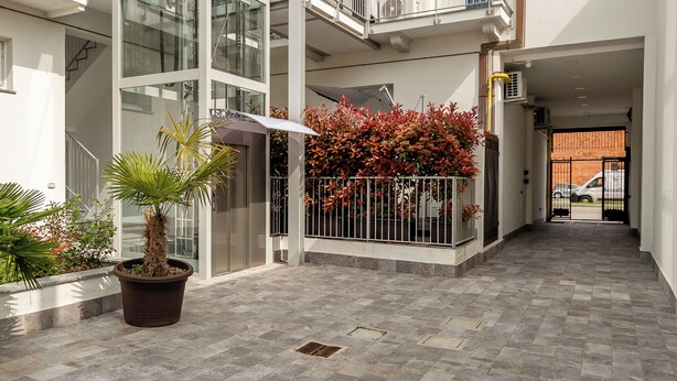A multi-story residential building with balconies, a courtyard, and potted plants. - KHL apartments (Milan)