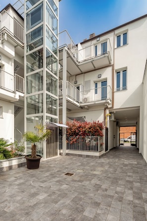 A multi-story residential building with balconies, a courtyard, and potted plants. - KHL apartments (Milan)