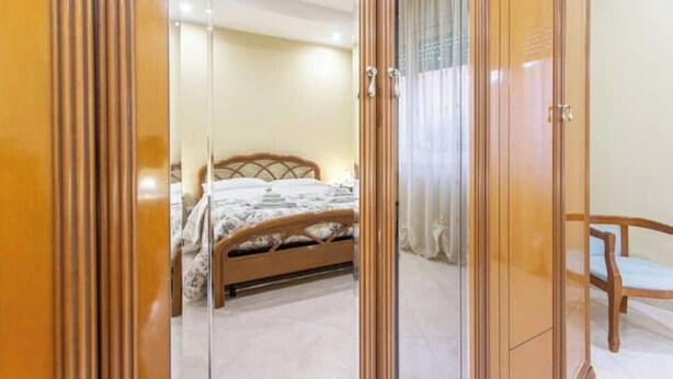 Une chambre à coucher avec un lit, une chaise en bois et une armoire.